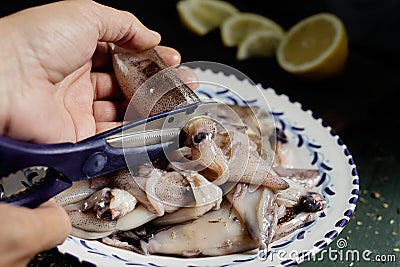 Man gutting some raw cuttlefishes Stock Photo