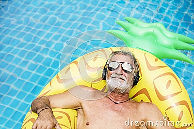 Closeup of caucasian senior man in the pool with headphones Stock Photo