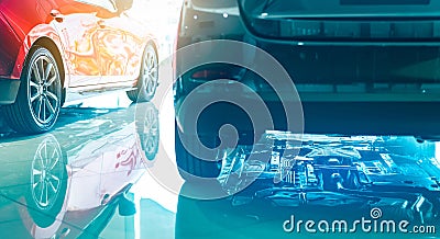 Closeup chassis, shaft, muffler of car reflected on shiny floor of showroom. New luxury car parked in modern showroom. Auto Stock Photo