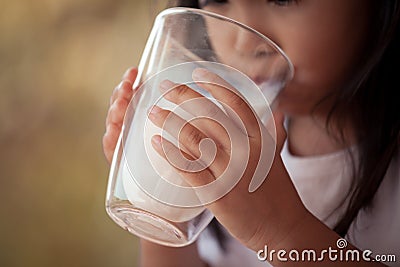 Closeup child hand holding and drinking a milk from glass Stock Photo