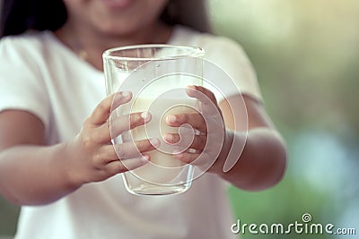 Closeup child hand holding a glass of milk Stock Photo