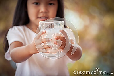 Closeup child hand holding a glass of milk Stock Photo