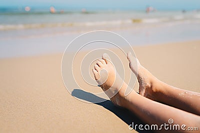 Closeup of a child`s feet laying on the beach Stock Photo