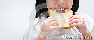 Closeup. Child`s hands holds the bread, kids teeth are bits chewing on the loaf of bread with gusto Stock Photo