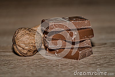 Closeup of chocolate bards and dry walnuts on a wooden surface Stock Photo