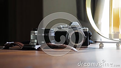 Closeup of classic camera on a wooden desk with digital watch and len equipment selected focus. Background with a beautiful Stock Photo