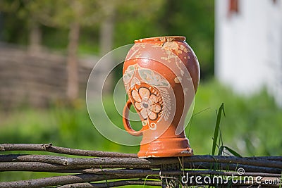 Closeup clay crock on a wooden fence Stock Photo