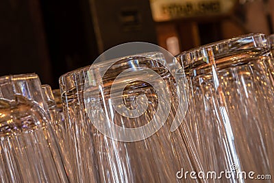 Closeup of shiny pint glasses in a row tipping from right to left Stock Photo