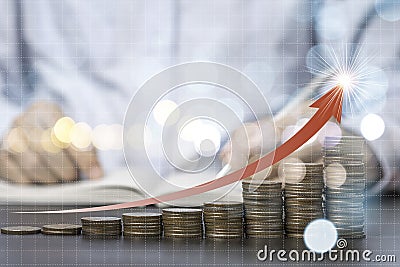 Closeup coins stacking with increase arrow with businessman background. Saving for investment concept Stock Photo