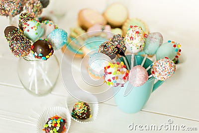 Closeup of colorful cake pops in cups on white wooden desk Stock Photo