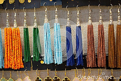 Closeup of colorful earrings with beads on the shelves under the lights Stock Photo