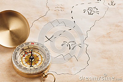 Closeup of compass over stained yellowed paper sheet with part of hand drawn treasure map Stock Photo