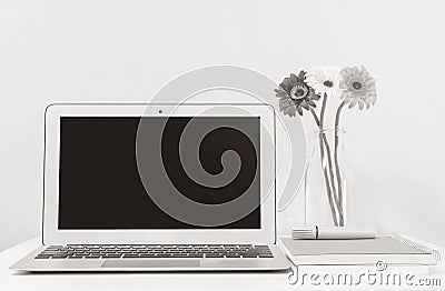 Closeup computer notebook on blurred white wood desk and wallpaper wall in room texture background , beautiful work place interior Stock Photo