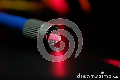 Closeup of connectors of optical fiber network cable. The laser shines from the optical cable Stock Photo