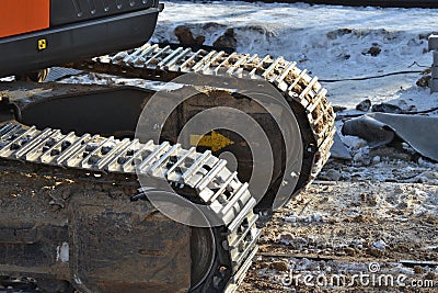 Closeup Continuous tracks or Tracked wheel of excavator or backhoe on the soil floor Stock Photo