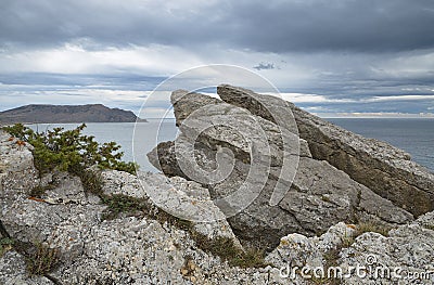 Closeup a cracked rocks against cloudy sky. Stock Photo