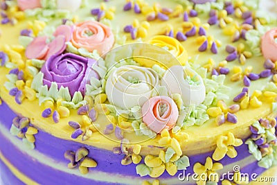 Closeup cream floral decoration on colorful cake Stock Photo