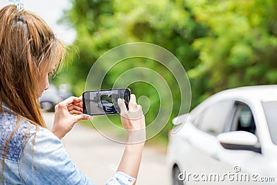 Closeup and crop female driver are using mobile phones to take photos as evidence for insurance claims Stock Photo