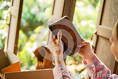 Closeup and crop female seller looking and checks the order of the leather goods in order to prepare the package to be sent to the Stock Photo