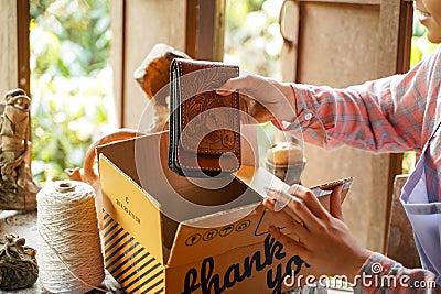 Closeup and crop female seller put the products ordered by customers into the parcel box and prepare to send to customers Stock Photo