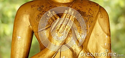 Closeup and crop hands of golden Buddha statue on blurred background Stock Photo