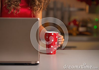 Closeup on cup of hot chocolate and woman usign laptop Stock Photo