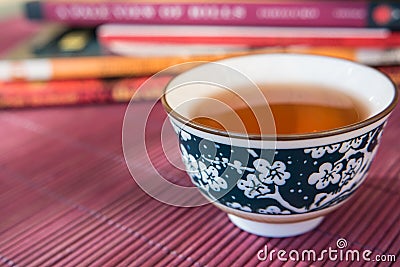 Closeup of a cup of tea and books in an outdoor shaded light Stock Photo