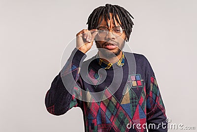 Closeup curious african man with dreadlocks adjusting his glasses for better vision, trying to peep secrets, spying Stock Photo