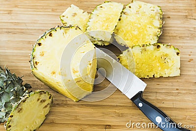 Closeup cutting a pineapple on wooden background Stock Photo