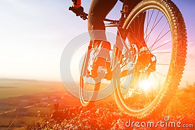 Closeup of cyclist man legs riding mountain bike on outdoor trail on hill Stock Photo