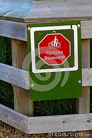 Closeup of a cyclists dismount sign on a fence Stock Photo