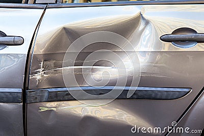 Closeup of damaged back door of car after accident on a road, dents and scratches on automobile body, side part of auto destroyed Stock Photo