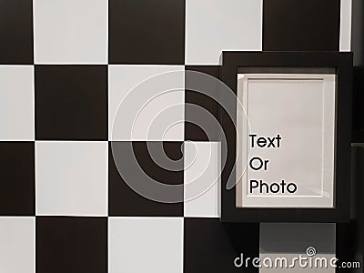 Decorate black photo frame on black and white chessboard pattern wall Stock Photo