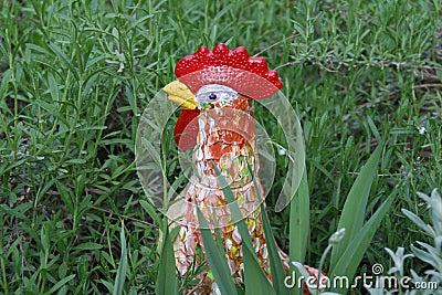 Closeup of a decorative rooster at a grassy garden Stock Photo