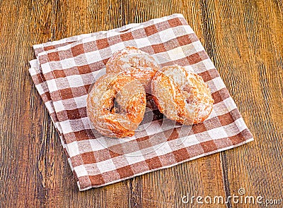 Closeup of delicious anise donuts on a checkered cloth over a wooden table Stock Photo