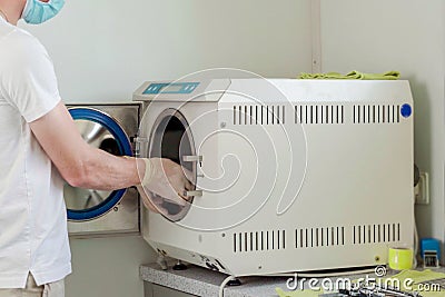 Closeup of dentist assistant sterilizing surgical dentistry tools in autoclave Stock Photo