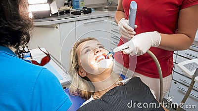 Closeup image of dentist assistant using saliva ejector Stock Photo