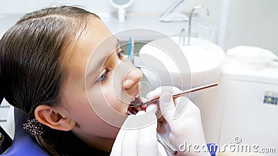 Closeup image of dentist hands in gloves examining girls teeth with instruments Stock Photo