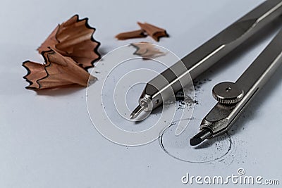 Closeup detail of a geometry pencil compass and pencil sharpening wood shavings on white paper with a drawn circle Stock Photo