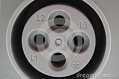 Closeup detail of gray plastic three phase electric wall plug, white background Stock Photo