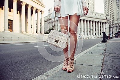 Closeup details of summer female casual street style outfit with luxury bag, skirt and high-heels. Fashionable girl standing at Ne Stock Photo