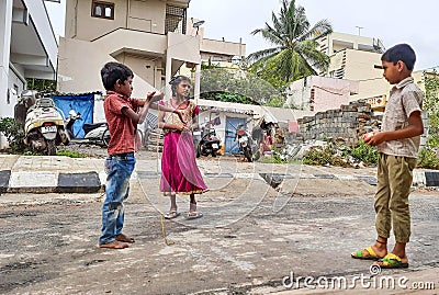 Closeup of different age group kids playing Buguri or Spinning Tops on Roadside during holiday Editorial Stock Photo