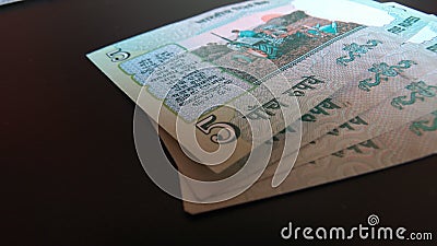 Closeup of discontinued Five Indian rupee note with an illustration of a tractor Cartoon Illustration