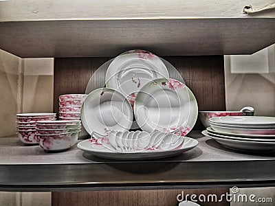 Closeup of dishes and bowls on wooden shelves Stock Photo