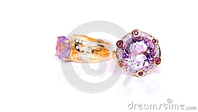 Closeup display of two exquisite rings adorned with gleaming amethyst stones, elegantly positioned on a pure white backdrop Stock Photo