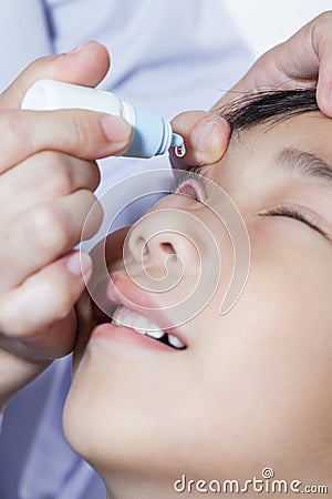 Closeup of doctor pouring eye drops in sick children Stock Photo