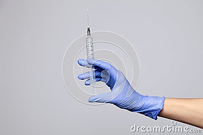 Closeup doctor's hand in rubber latex purple glove hold transparent syringe. Isolated on white background. Concept rejection of Stock Photo