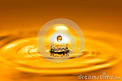 Closeup on drop of cosmetic golden oil liquid. Stock Photo