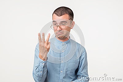 Closeup of drunk young man looking in his fingers trying to count them. Stock Photo