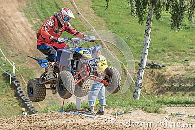 Closeup dynamic shot of quad rider in red jumping Editorial Stock Photo